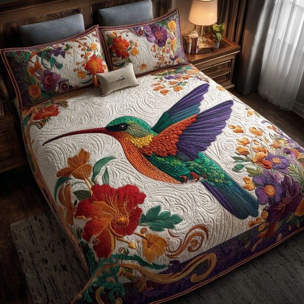 Hummingbird Dream quilted 3-piece bedding set on a made bed with two matching pillow shams