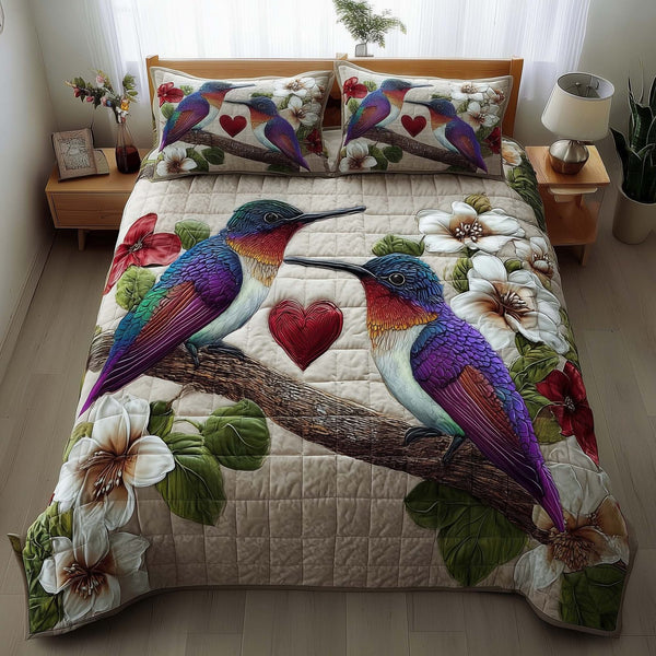 Hummingbird Embrace quilted 3-piece bedding set on a made bed with two matching pillow shams