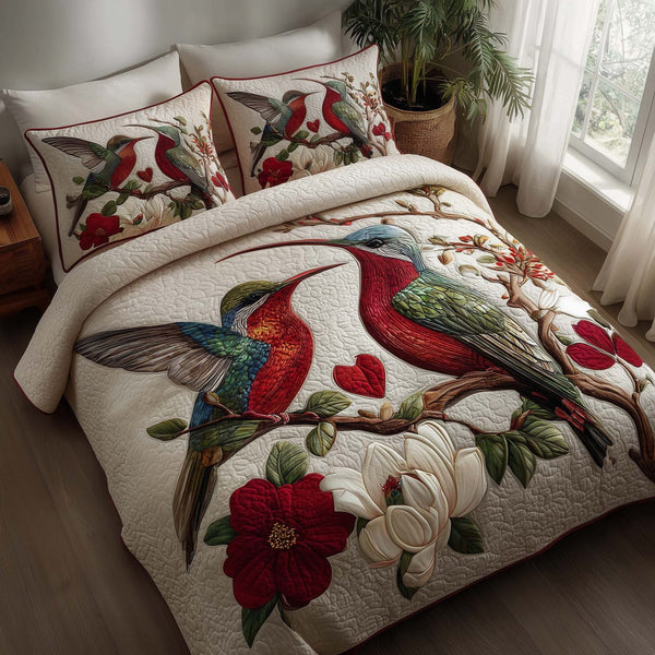 Hummingbird Embrace quilted 3-piece bedding set on a made bed with two matching pillow shams