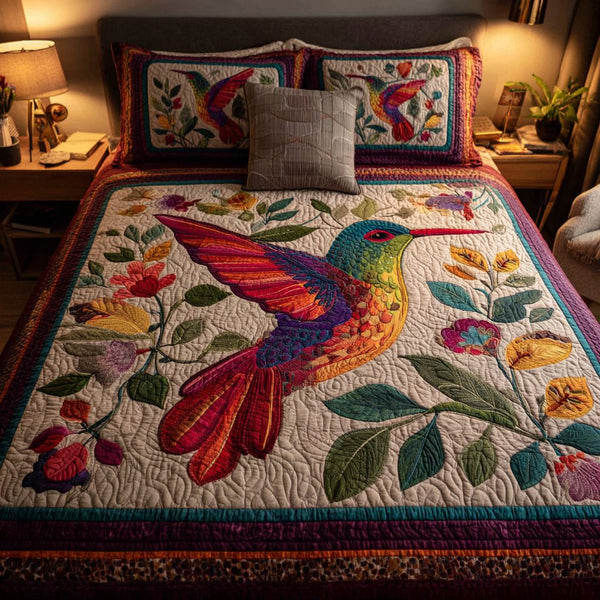 Hummingbird Flare quilted 3-piece bedding set on a made bed with two matching pillow shams