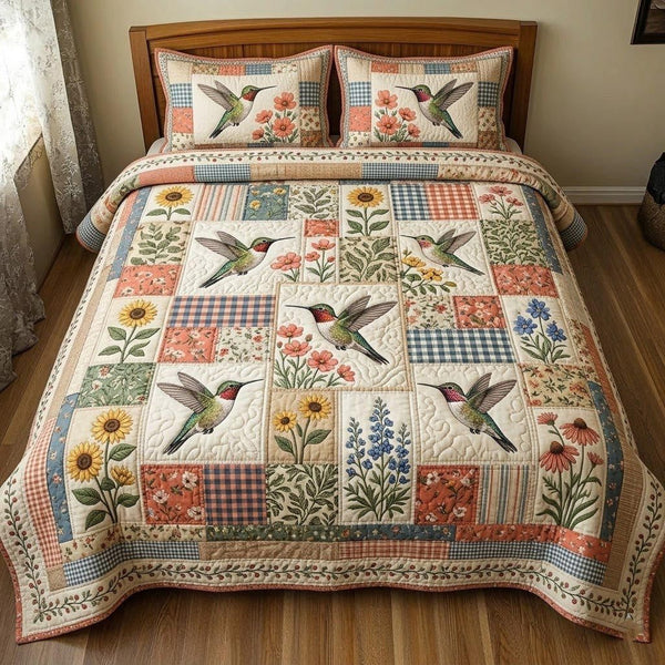 Hummingbird Garden quilted 3-piece bedding set on a made bed with two matching pillow shams