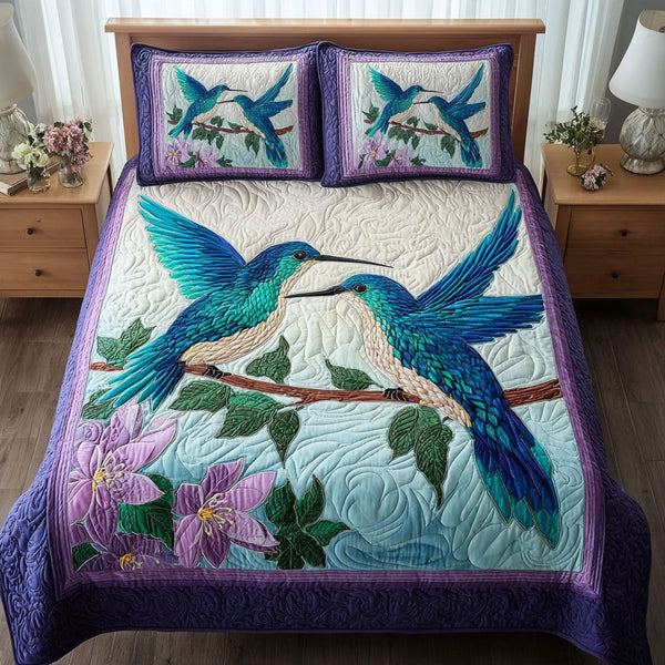 Hummingbird Garden quilted 3-piece bedding set on a made bed with two matching pillow shams