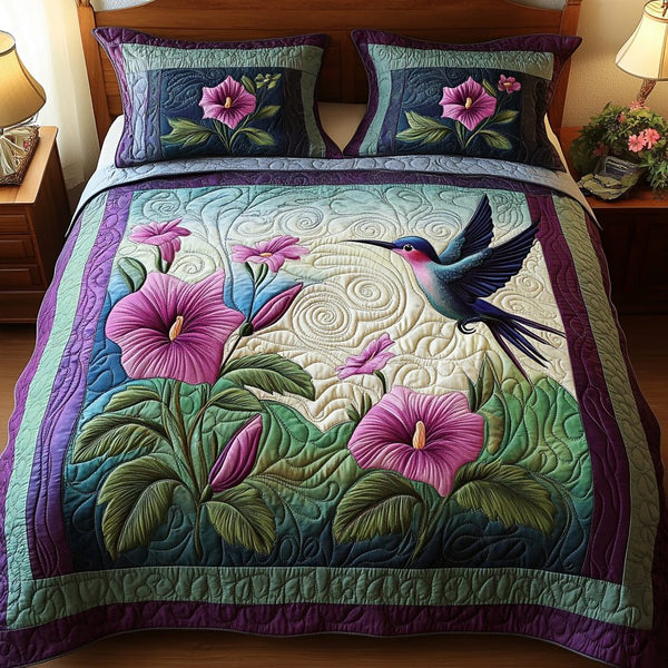 Hummingbird Garden quilted 3-piece bedding set on a made bed with two matching pillow shams