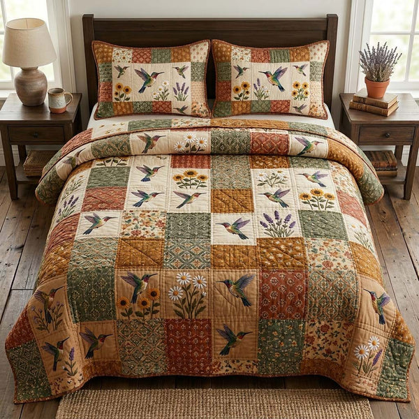 Hummingbird Grace quilted 3-piece bedding set on a made bed with two matching pillow shams