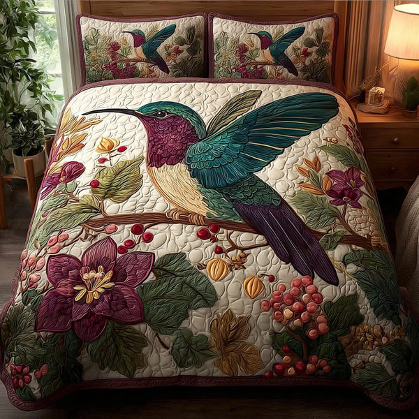 Hummingbird Grace quilted 3-piece bedding set on a made bed with two matching pillow shams