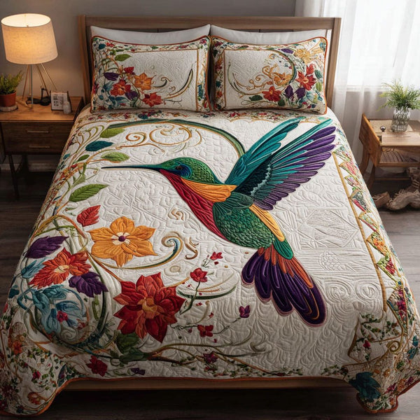 Hummingbird Harmony quilted 3-piece bedding set on a made bed with two matching pillow shams