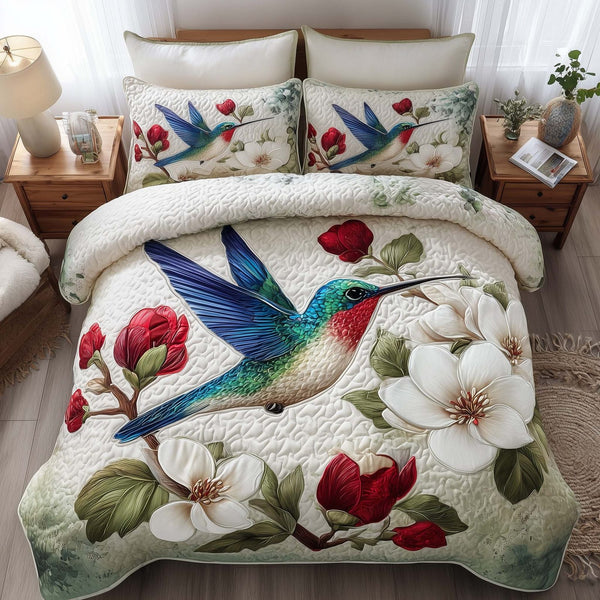 Hummingbird Haven quilted 3-piece bedding set on a made bed with two matching pillow shams