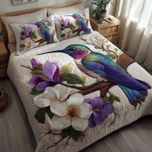 Hummingbird Haven quilted 3-piece bedding set on a made bed with two matching pillow shams