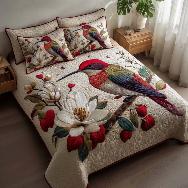 Hummingbird Haven quilted 3-piece bedding set on a made bed with two matching pillow shams