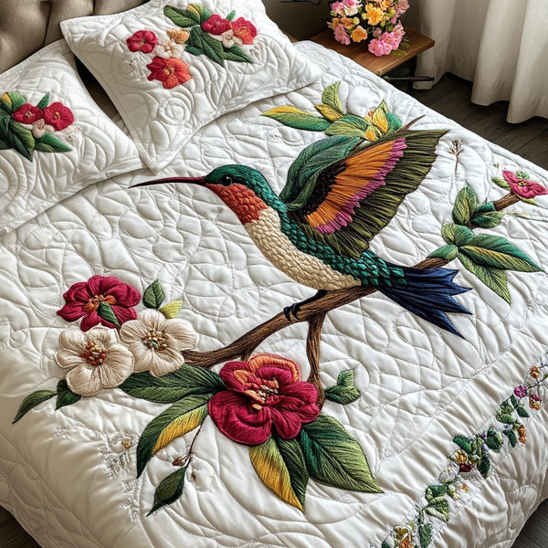 Hummingbird Haven quilted 3-piece bedding set on a made bed with two matching pillow shams