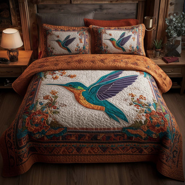 Hummingbird Heaven quilted 3-piece bedding set on a made bed in a softly lit bedroom