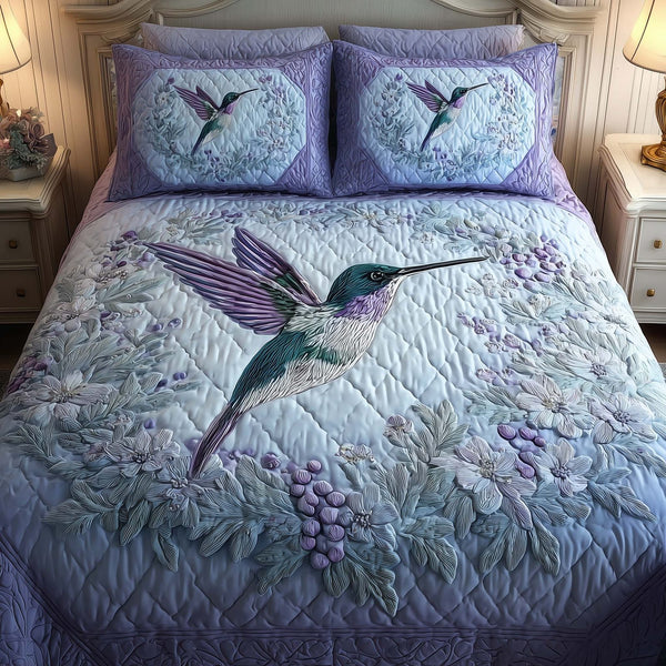 Hummingbird Heaven quilted 3-piece bedding set on a made bed in a softly lit bedroom