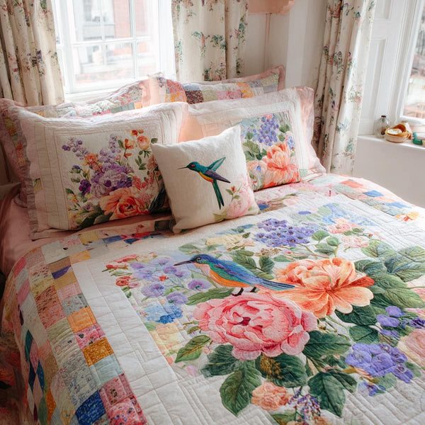 Hummingbird Meadow quilted 3-piece bedding set on a made bed with two matching pillow shams