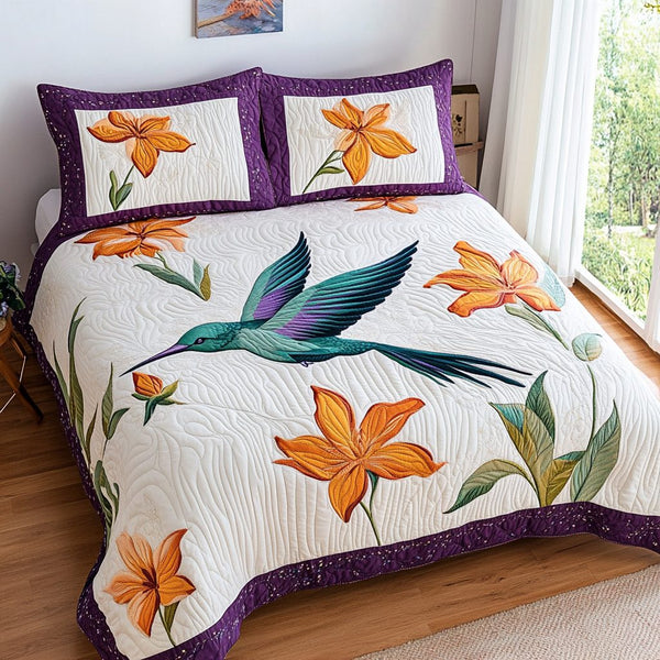 Hummingbird Melody quilted 3-piece bedding set on a made bed with two matching pillow shams