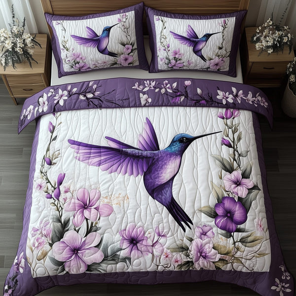 Hummingbird quilted 3-piece bedding set on a made bed with two matching pillow shams