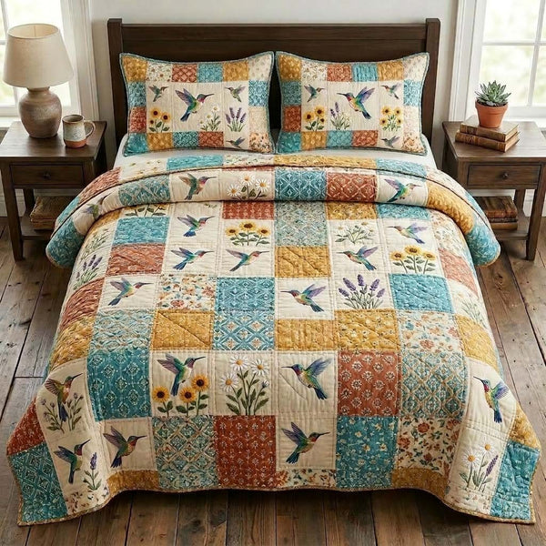 Hummingbird quilted 3-piece bedding set on a made bed with two matching pillow shams