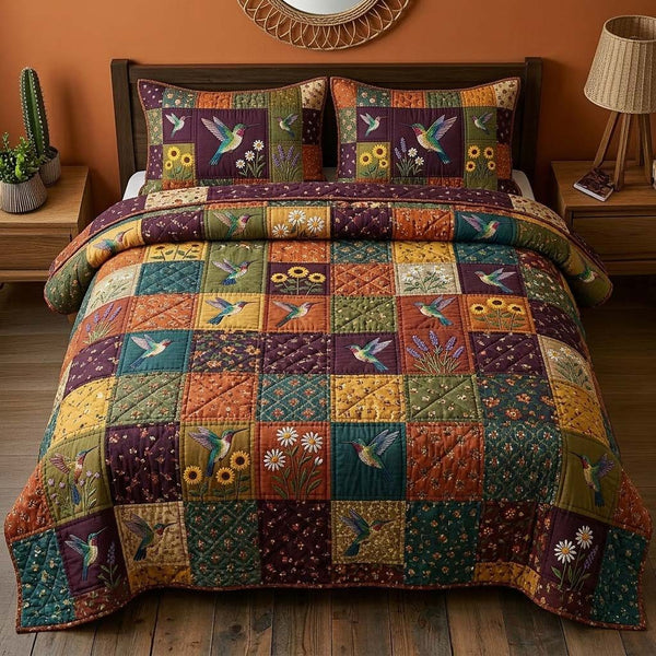 Hummingbird quilted 3-piece bedding set on a made bed with two matching pillow shams
