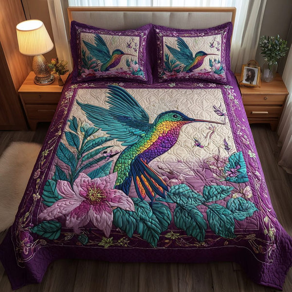 Hummingbird Rush quilted 3-piece bedding set on a made bed with two matching pillow shams