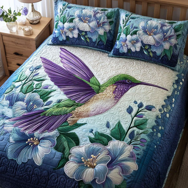 Hummingbird Spirit quilted 3-piece bedding set on a made bed with two matching pillow shams