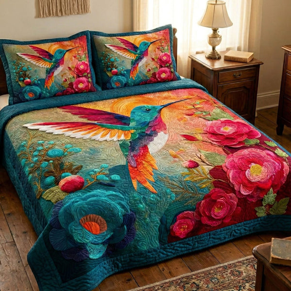 Hummingbird Sunset quilted 3-piece bedding set on a made bed with two matching pillow shams