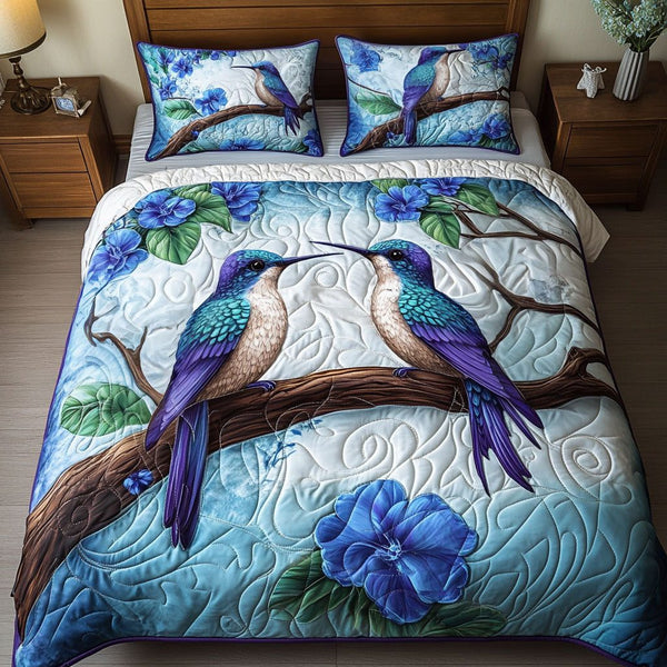 Hummingbird Whisper quilted 3-piece bedding set on a made bed with two matching pillow shams