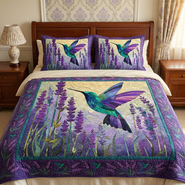 Lavender Hummingbird quilted 3-piece bedding set on a made bed with two matching pillow shams