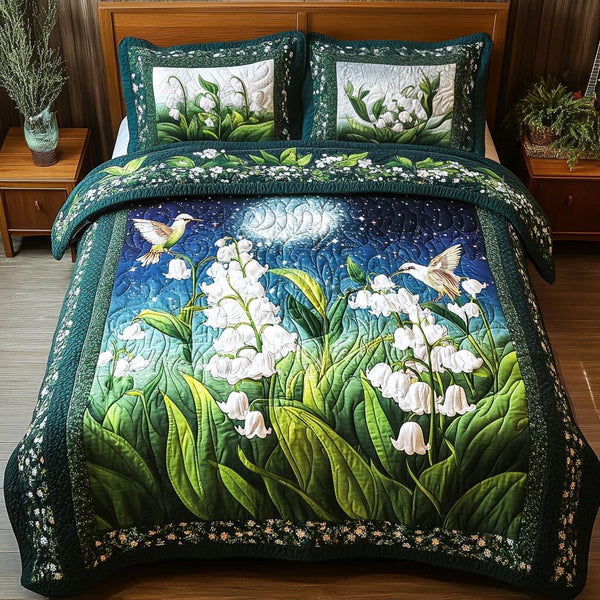 Lily Hummingbird quilted 3-piece bedding set on a made bed with two matching pillow shams