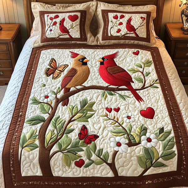 Love Birds quilted 3-piece bedding set on a made bed with two matching pillow shams