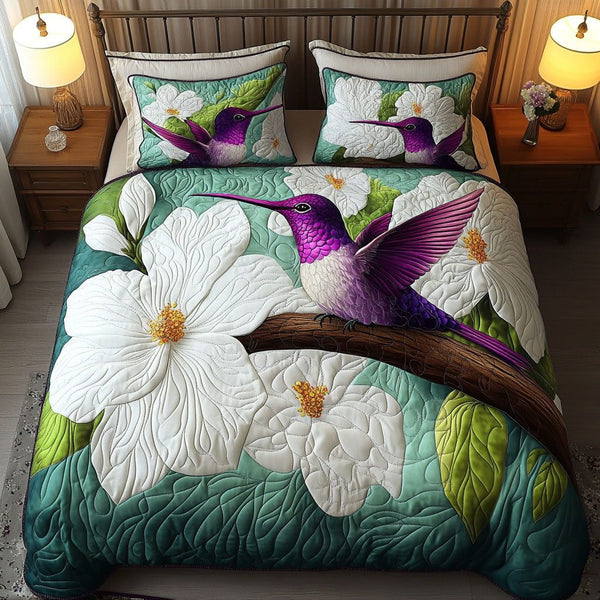 Magnolia and Hummingbird quilted 3-piece bedding set on a made bed with two matching pillow shams
