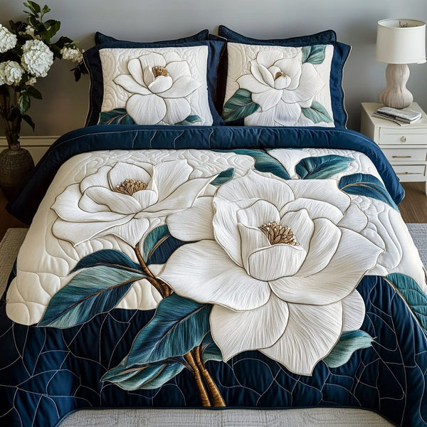 Magnolia Tranquil quilted 3-piece bedding set on a made bed with two matching pillow shams