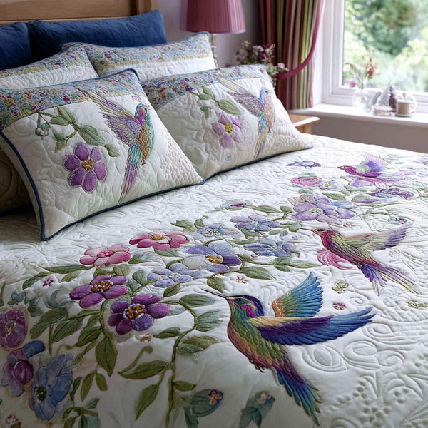 Morning Hummingbird quilted 3-piece bedding set on a made bed with two matching pillow shams