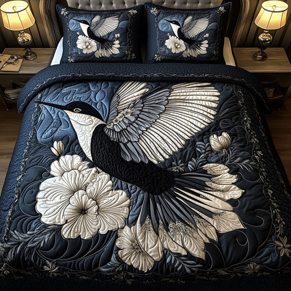 Noir Hummingbird quilted 3-piece bedding set on a made bed with two matching pillow shams