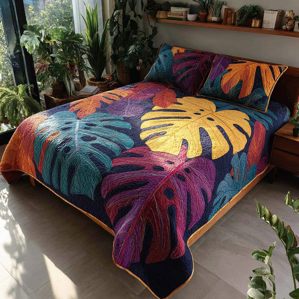 Painted Monstera quilted 3-piece bedding set on a made bed with two matching pillow shams