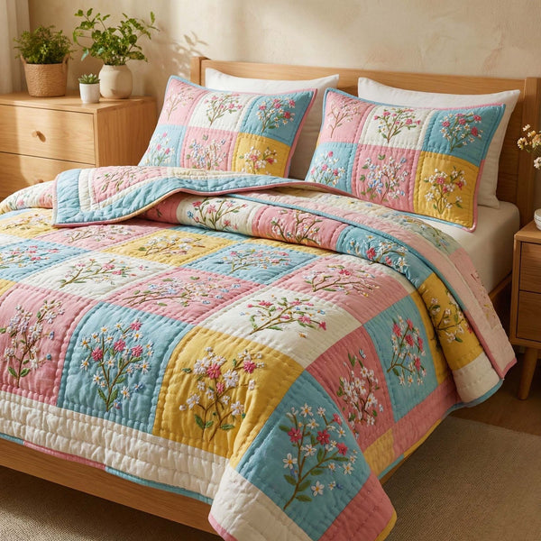 Pastel Blossoms quilted 3-piece bedding set on a made bed with two matching pillow shams