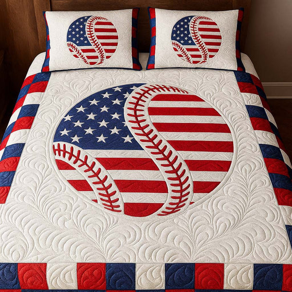Patriotic Curveball quilted 3-piece bedding set on a made bed in a warmly lit bedroom