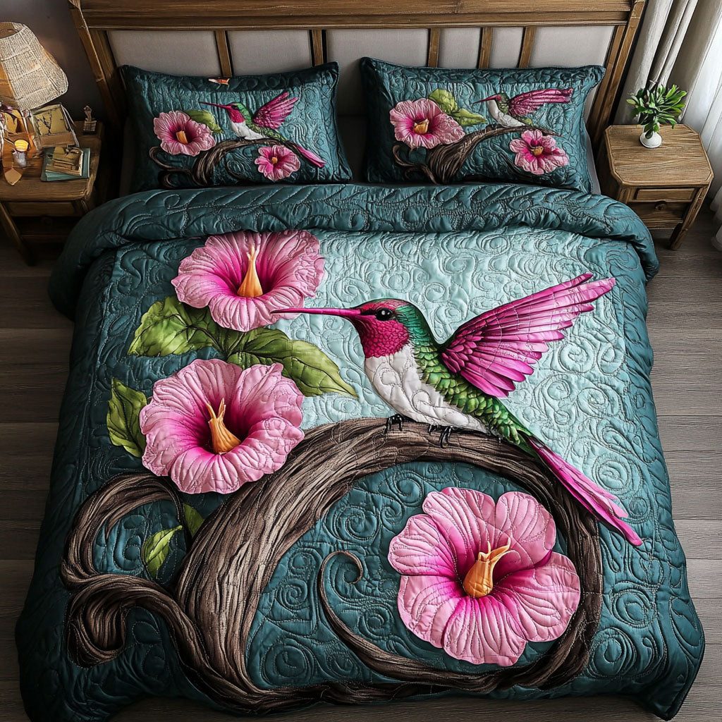 Pink Hummingbird quilted 3-piece bedding set on a made bed with two matching pillow shams