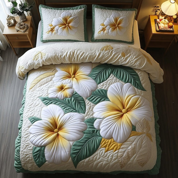 Plumeria Bliss quilted 3-piece bedding set on a made bed with two matching pillow shams