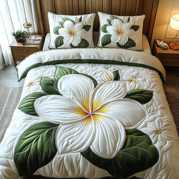 Plumeria Bliss quilted 3-piece bedding set on a made bed with two matching pillow shams