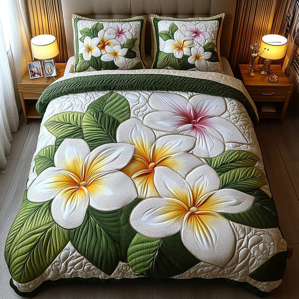 Plumeria Bloom quilted 3-piece bedding set on a made bed with two matching pillow shams