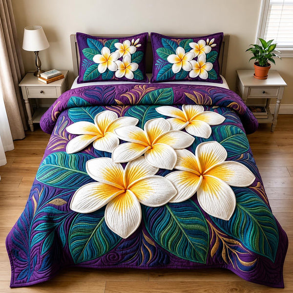 Plumeria Blossom quilted 3-piece bedding set on a made bed with two matching pillow shams
