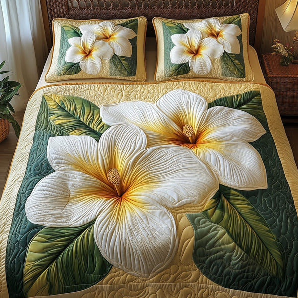 Plumeria Dreams quilted 3-piece bedding set on a made bed with two matching pillow shams