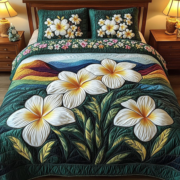 Plumeria Glow quilted 3-piece bedding set on a made bed with two matching pillow shams