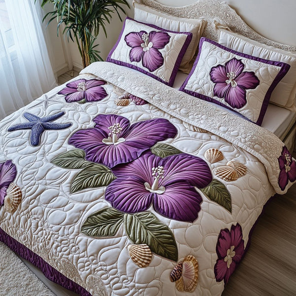 Purple Hibiscus quilted 3-piece bedding set on a made bed with two matching pillow shams