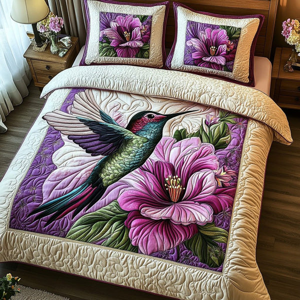 Purple Hummingbird quilted 3-piece bedding set on a made bed with two matching pillow shams