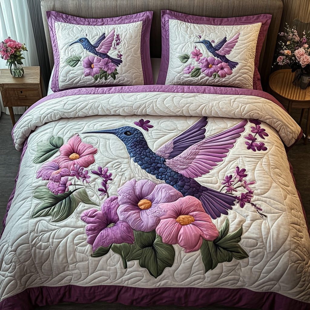 Purple Hummingbird quilted 3-piece bedding set on a made bed with two matching pillow shams
