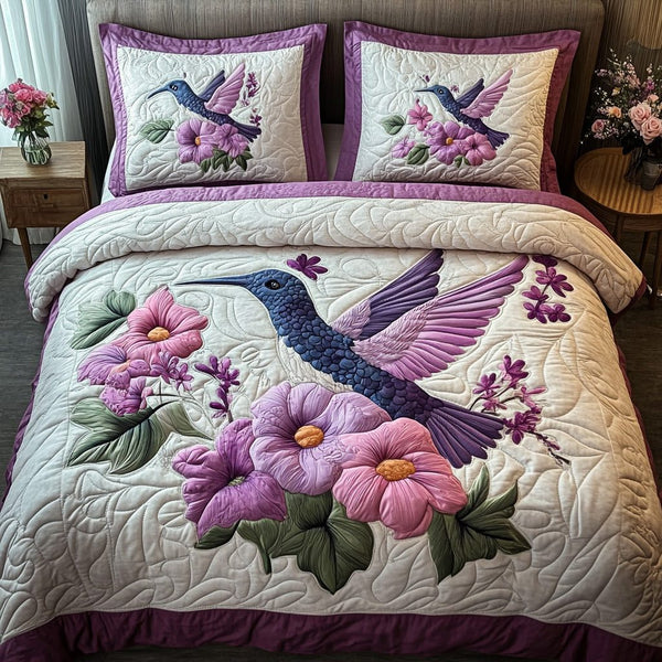 Purple Hummingbird quilted 3-piece bedding set on a made bed with two matching pillow shams