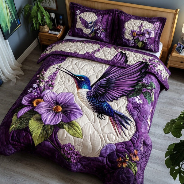 Purple Hummingbird quilted 3-piece bedding set on a made bed with two matching pillow shams