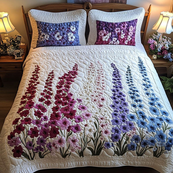 Purple Mist Flowers quilted 3-piece bedding set on a made bed with two matching pillow shams
