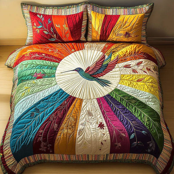 Radiant Hummingbird quilted 3-piece bedding set on a made bed with two matching pillow shams
