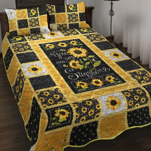 Sunflower Sunshine quilted 3-piece bedding set on a made bed with two matching pillow shams